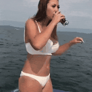 девушка пьет, стоя на яхте gif