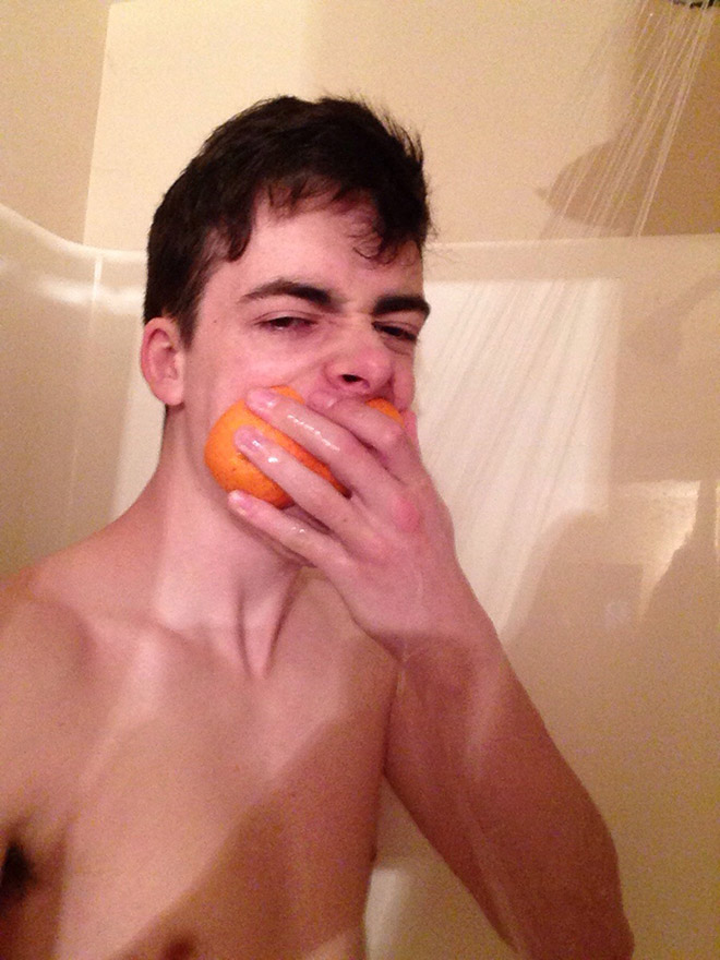 парень ест апельсин