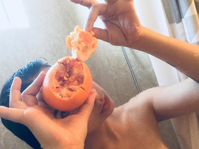 девушка чистит апельсин