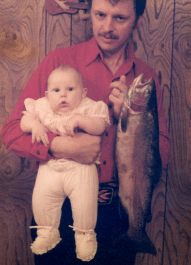 отец с дочкой на руках и рыба