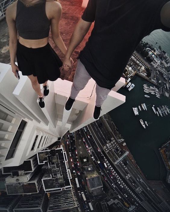 парень и девушка стоят на краю крыши