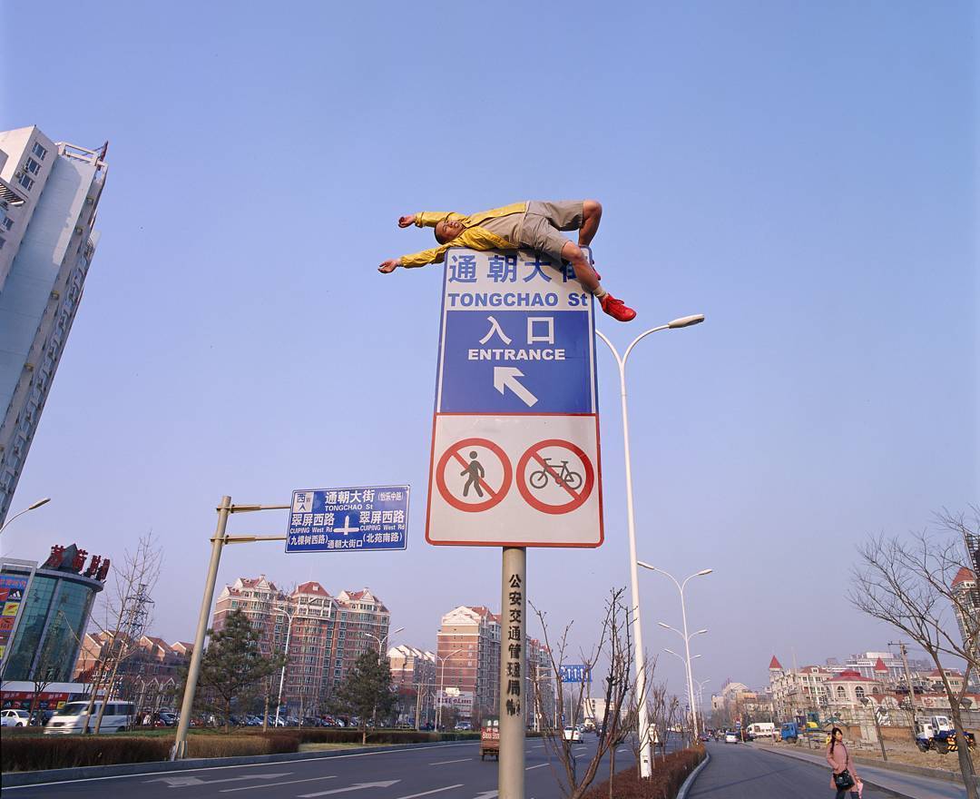 мужчина верхом на дорожном знаке