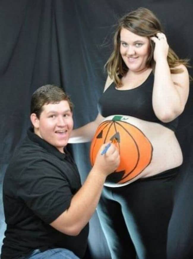 муж рисует на животе беременной жены