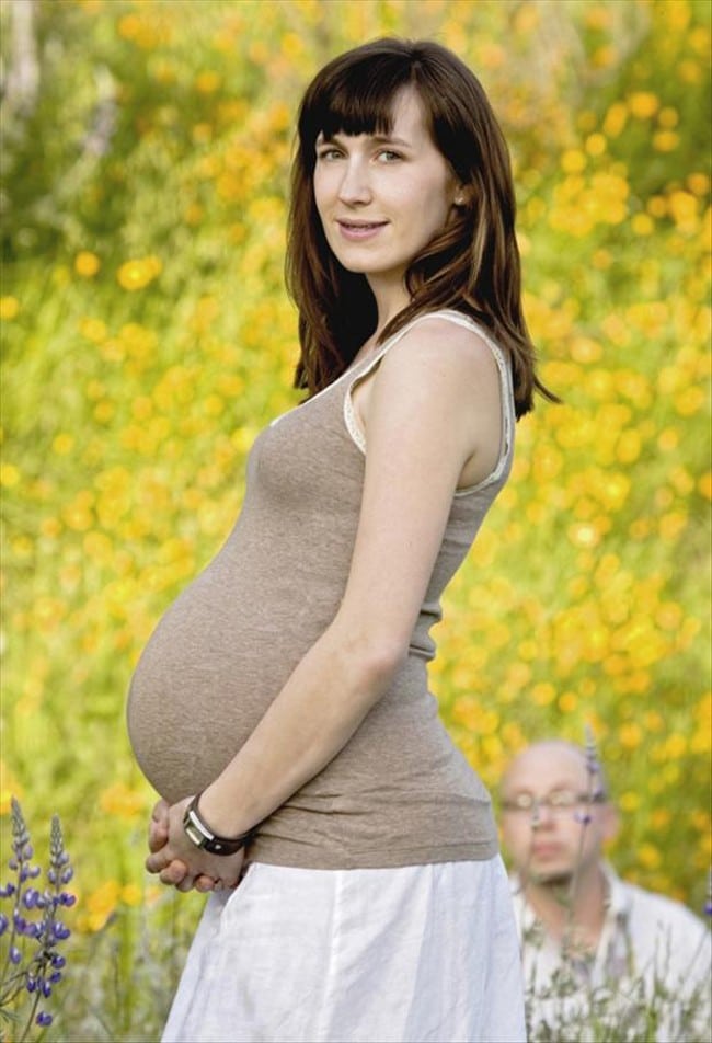 беременная женщина и мужчина на заднем фоне