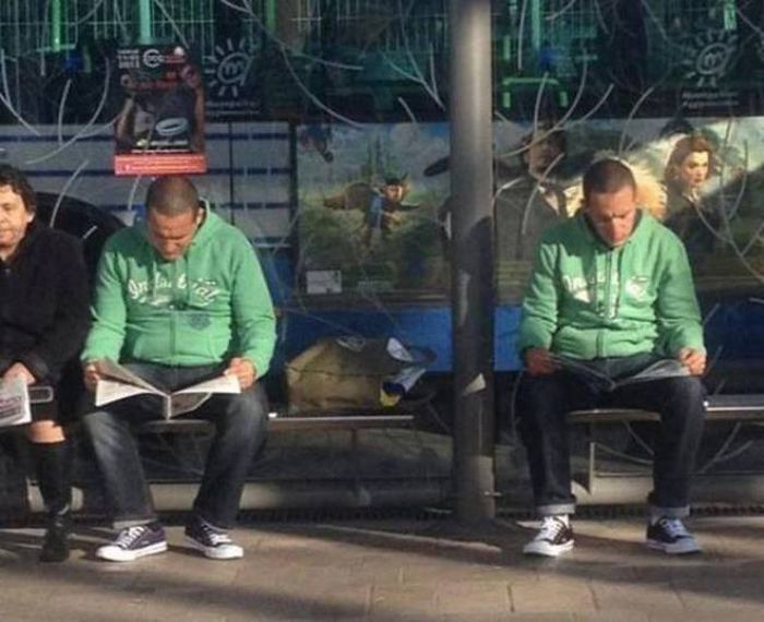 мужчины читают в парке на скамье