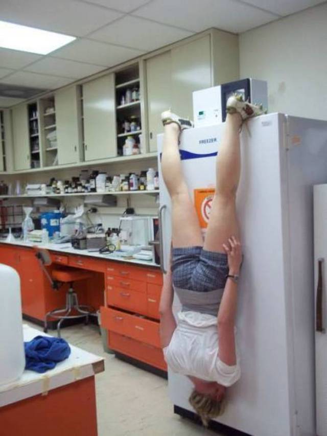 девушка висит на холодильнике вверх ногами