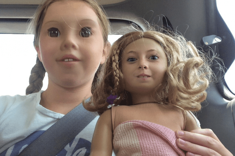 девочка с куклой в машине