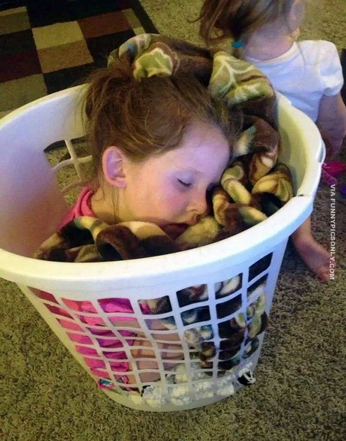 девочка спит в корзине для белья