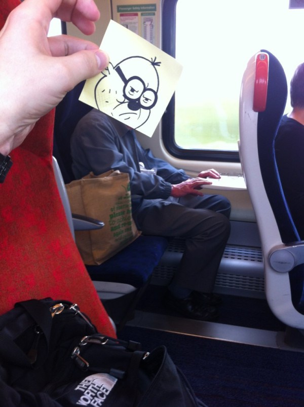 мужчина в поезде с мультяшной головой