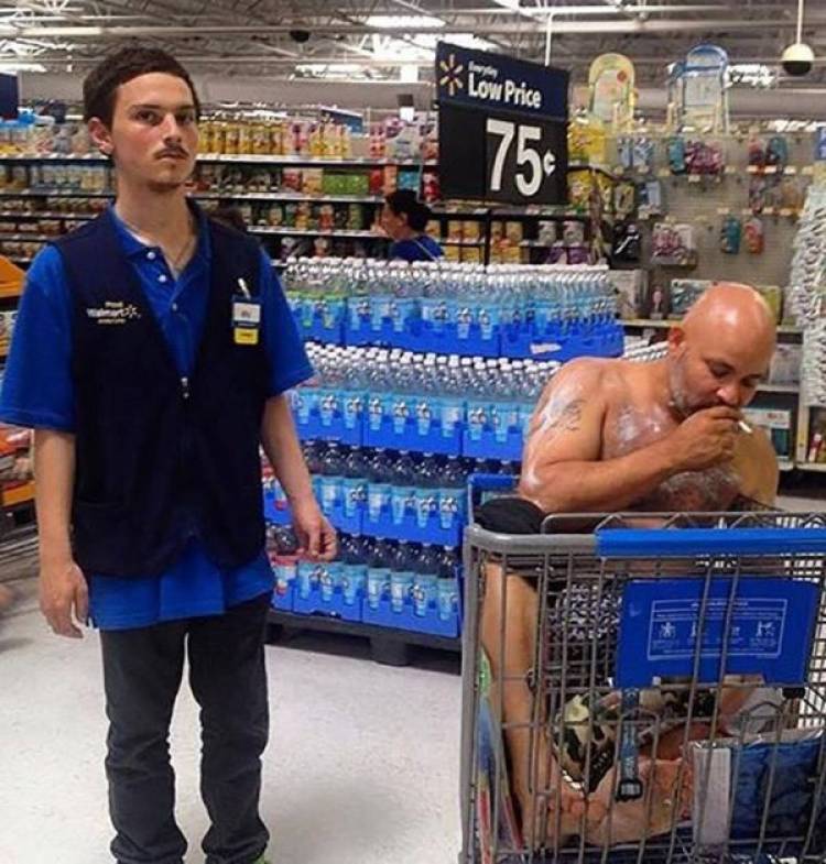 мужчина сидит в тележке в супермаркете