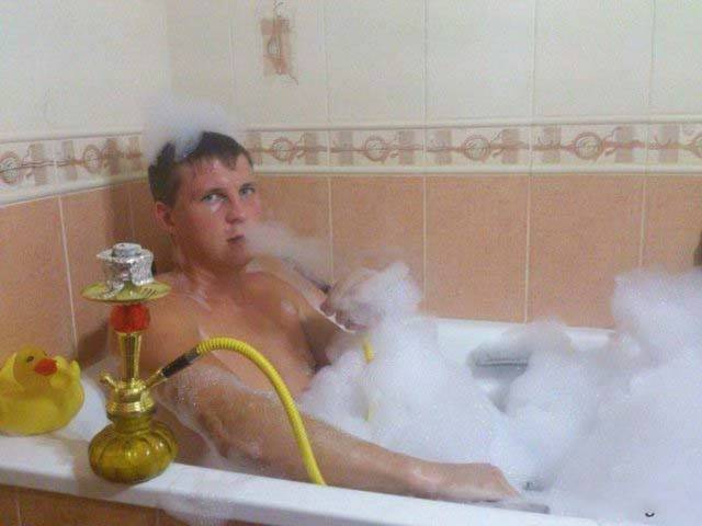 мужчина принимает ванну с пеной и кальяном