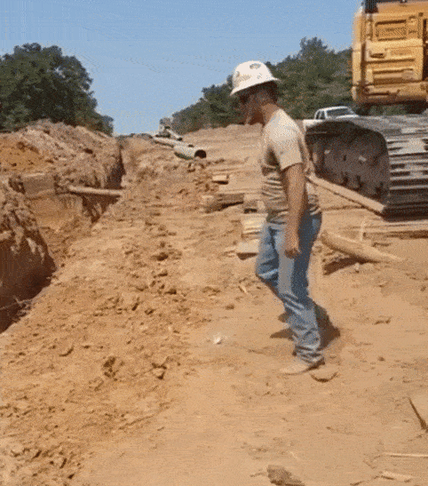 строитель перепрыгивает яму