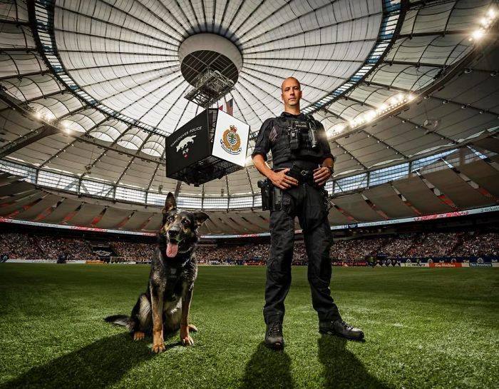 полицейский с собакой на футбольном поле