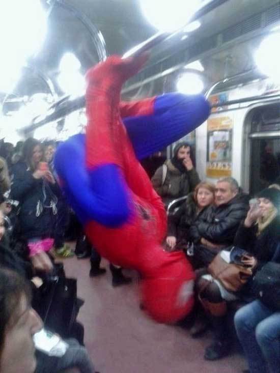 человек-паук висит на поручне в метро