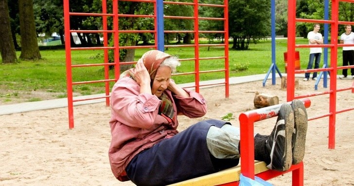 старушка качает пресс на детской площадке
