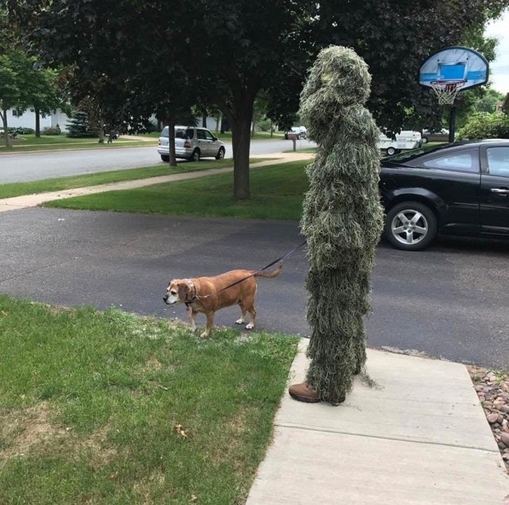 человек в странном костюме с собакой