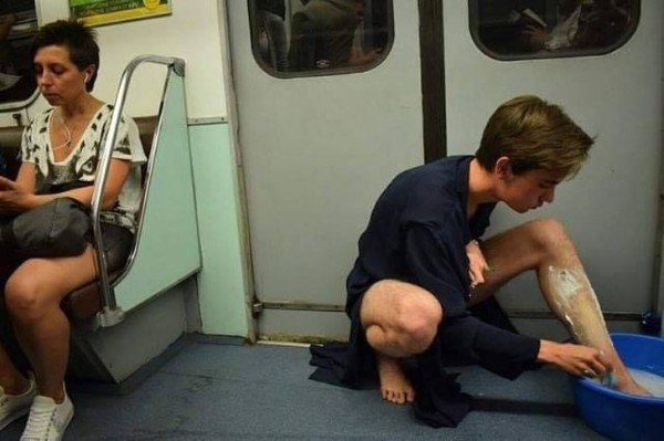 парень бреет ноги в метро