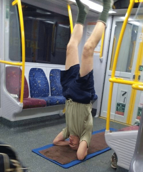 мужчина стоит на голове в метро