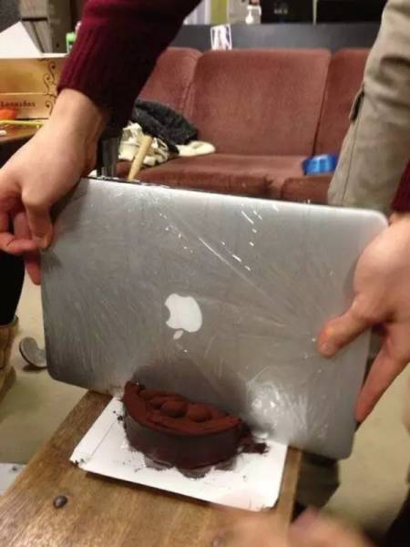 парень режет торт ноутбуком