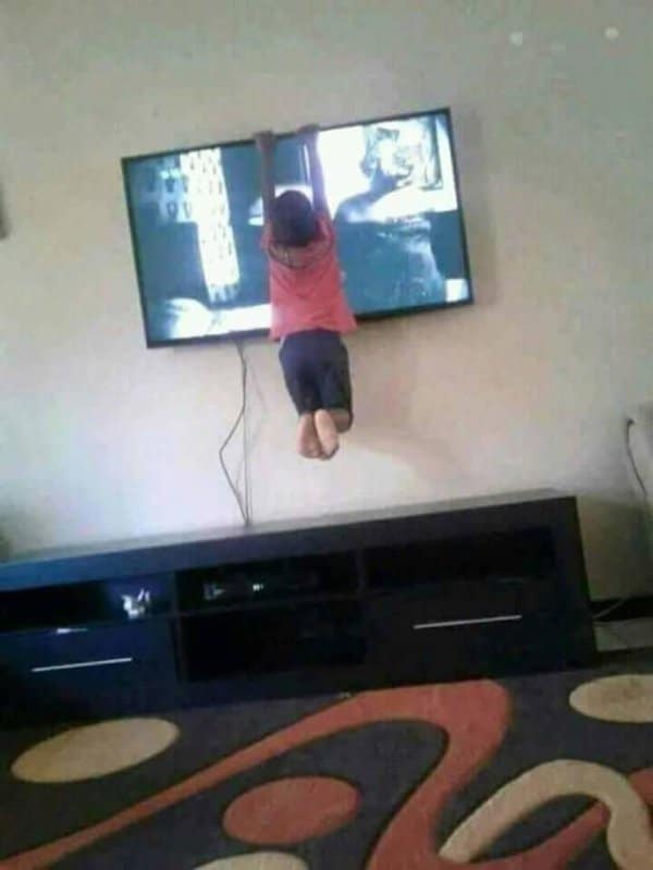 мальчик висит на плазменном телевизоре