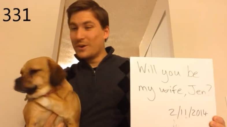 мужчина с собакой и листом бумаги со словами "Выходи за меня замуж"