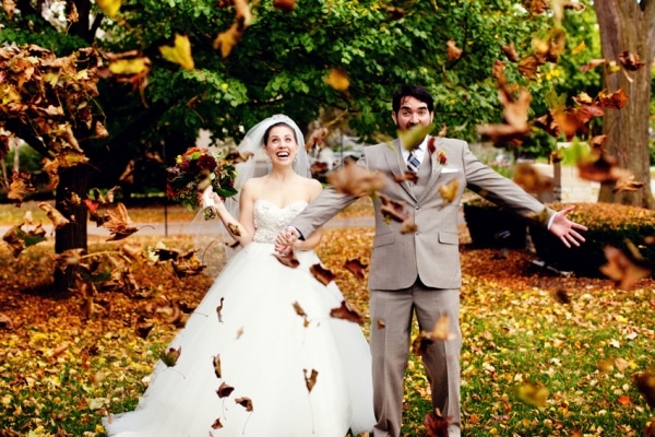 невеста и жених бросают осенние листья