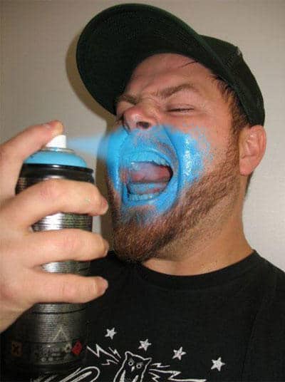 мужчина брызгает краску в рот
