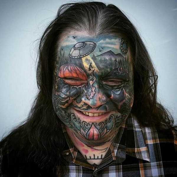 мужчина с лицом в татуировках