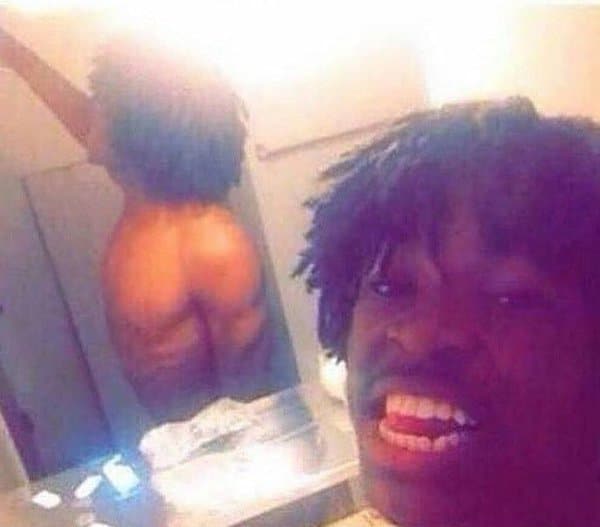 чернокожий парень делает селфи перед зеркалом