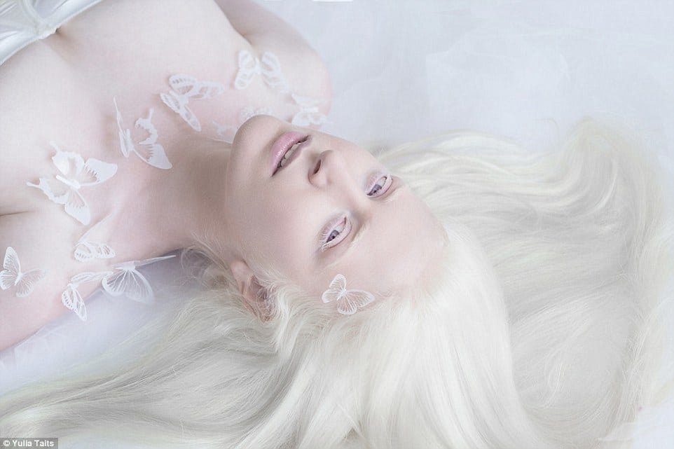 Девушка-альбинос лежит на белом