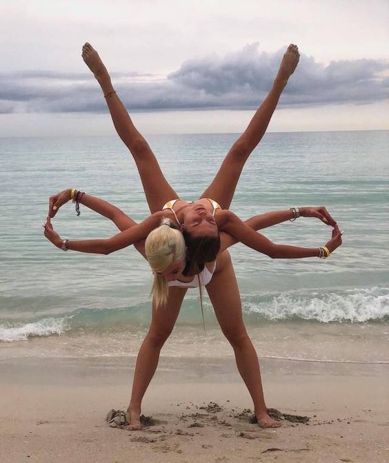 девушки на пляже практикуют йогу