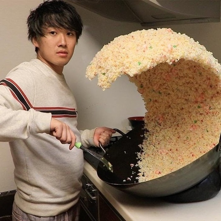 парень перемешивает рис в сковороде