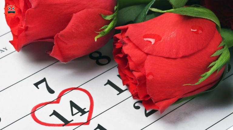 red roses lay on the calendar with the date of February 14 Valentine's day