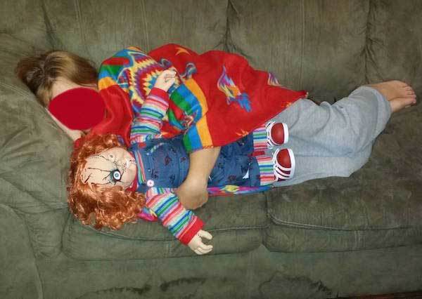 девочка спит с куклой на диване