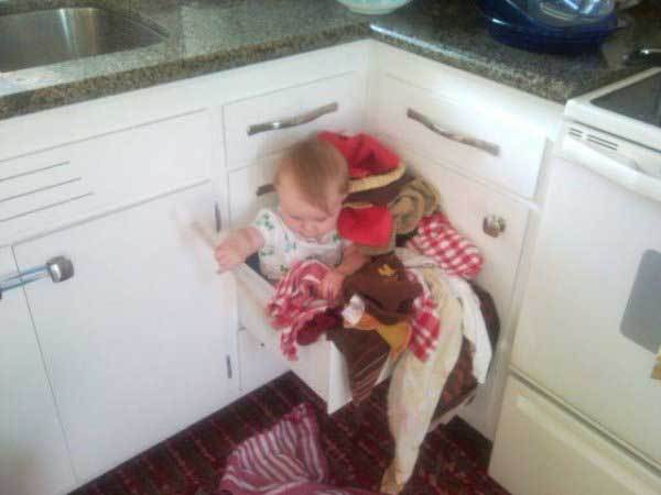 ребенок сидит в кухонном ящике