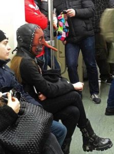 женщина в кожаной маске в вагоне метро