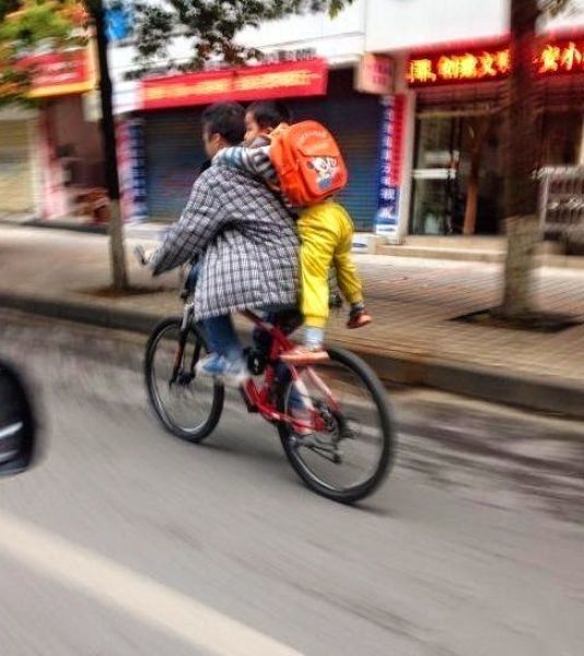 велосипедист с ребенком на спине