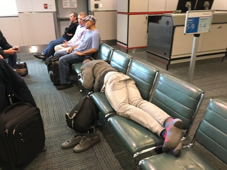 мужчина спит на креслах в зале ожидания