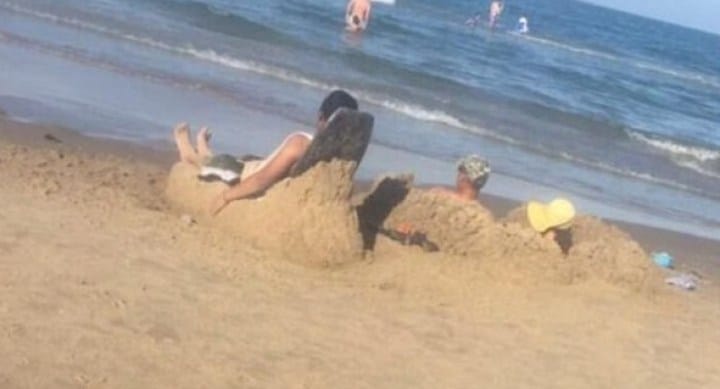 парень лежит на кресле из песка