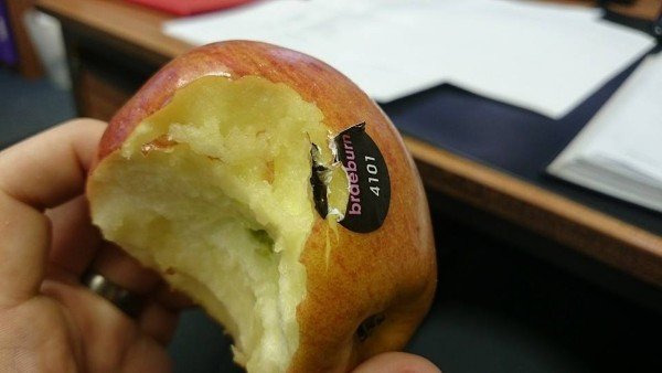 надкушенное яблоко с наклейкой