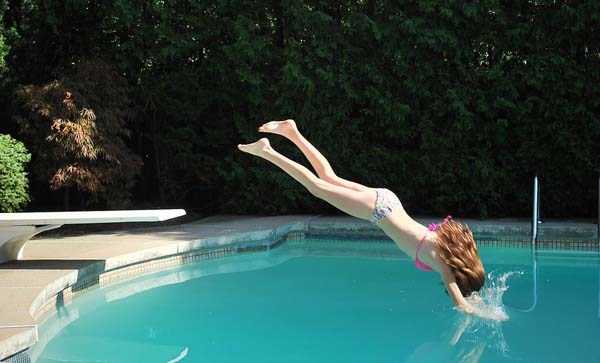 девушка ныряет в бассейн