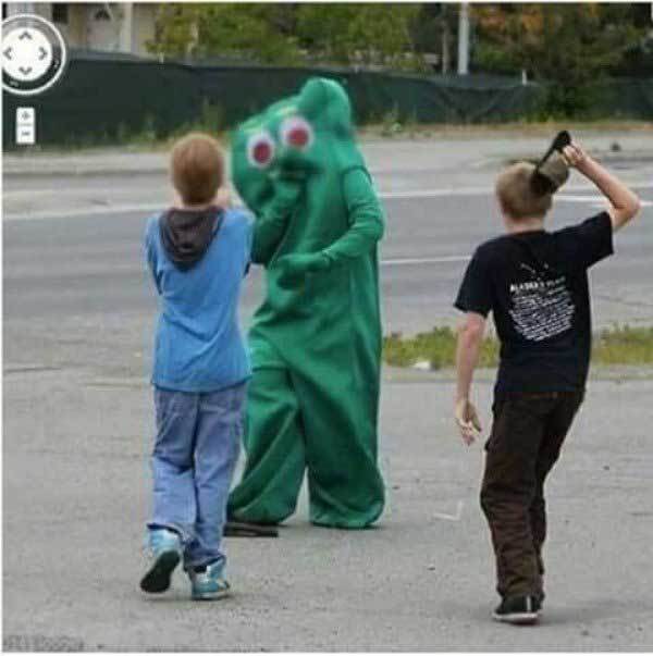 подростки бьют человека в зеленом костюме