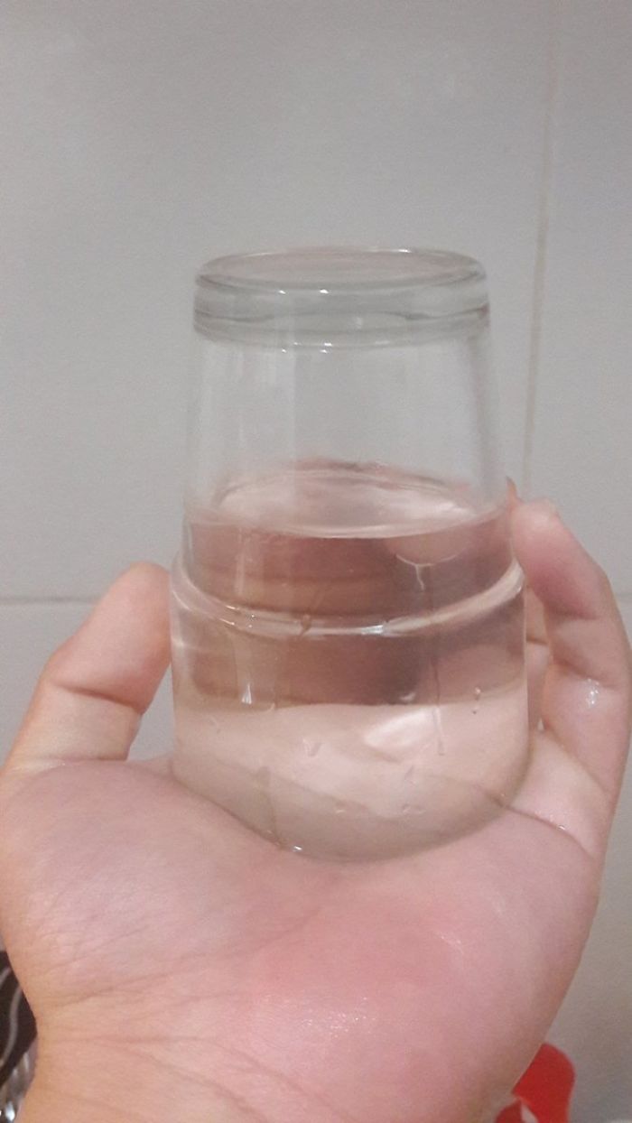 перевернутый стакан с водой на ладони