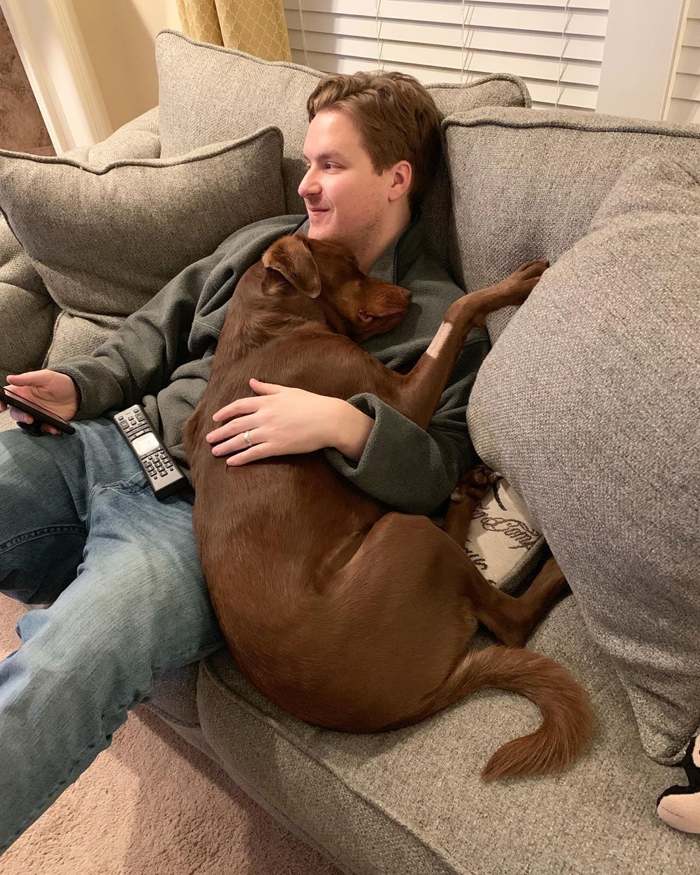 парень с собакой на диване