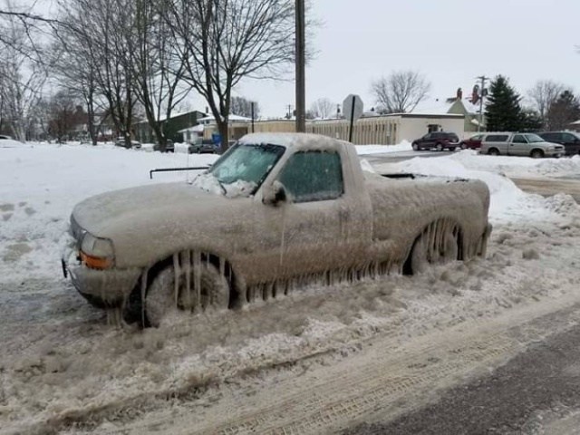 машина покрытая льдом на дороге