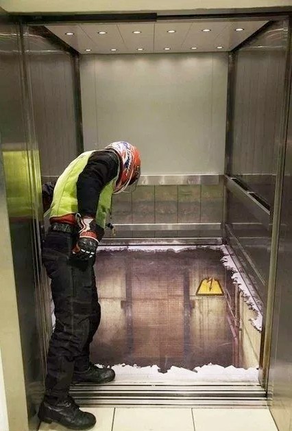 парень заглядывает в кабинку лифта
