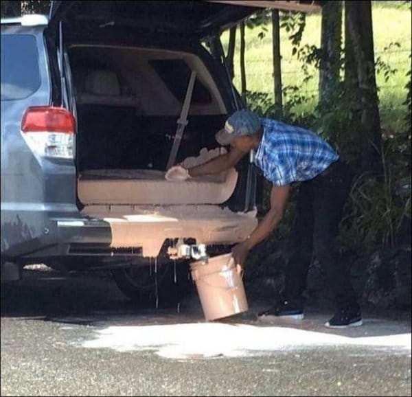 мужчина собирает разлитую в машине краску