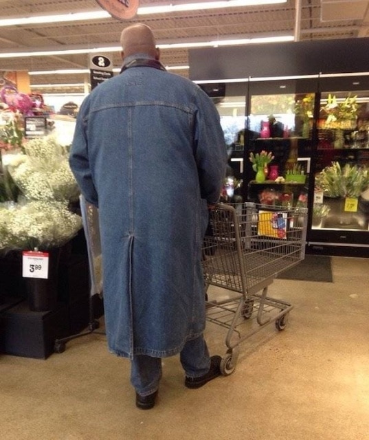 мужчина в джинсовом плаще в супермаркете