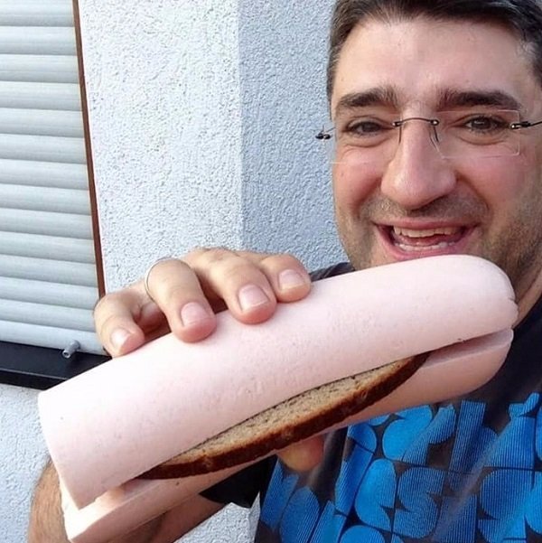 мужчина с колбасой в руке