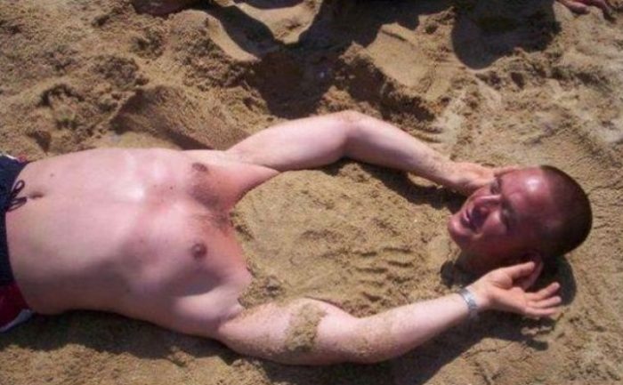парень зарытый в песок